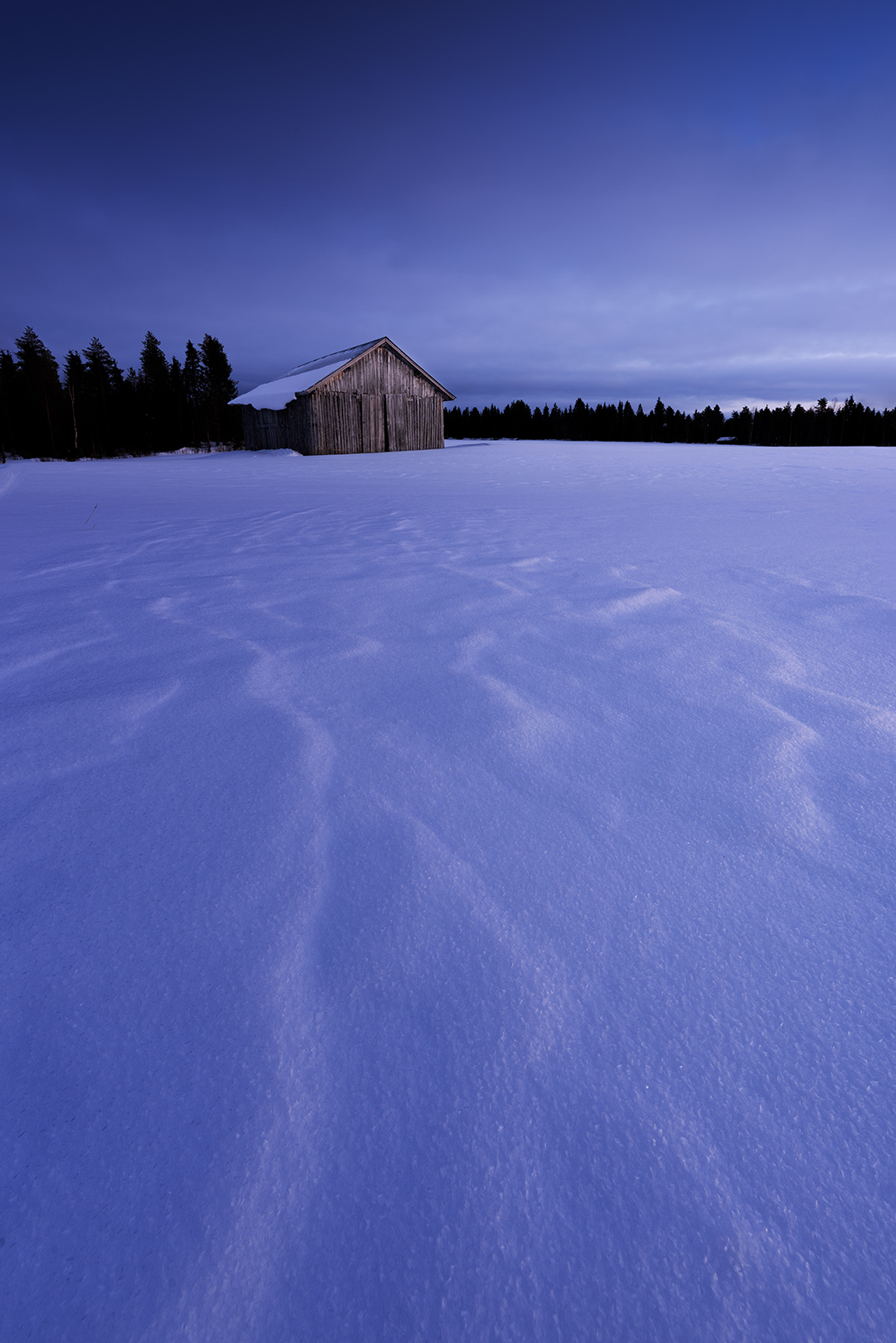 Photo minimaliste en Finlande montrant une cabane isolée dans un paysage enneigé illustrant l’importance de simplifier sa composition