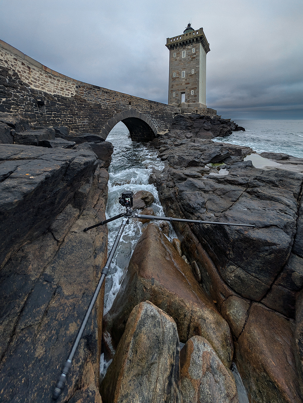 Benro Mammoth TMTH44C au phare de Kermorvan Trépied Benro Mammoth TMTH44C posé au-dessus d'une faille rocheuse, jambes écartées de part et d'autre, au phare de Kermorvan
