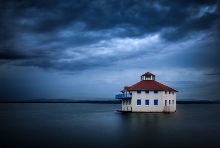 Lonely. Une maison seule, flottant entre ciel et eau, Cap Coudalère, Pyrénées-Orientales. Maison isolée semblant flotter sur l'eau, ciel orageux, Cap Coudalère, Pyrénées-Orientales.