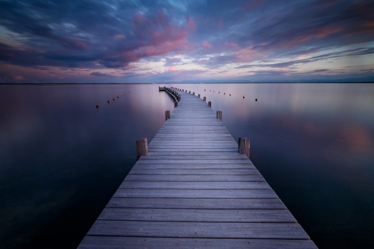 Serenity. Un ponton à l'heure bleue du soir, Aude, Occitanie. Ponton en bois s'avançant sur une eau calme, heure bleue, Aude, Occitanie.