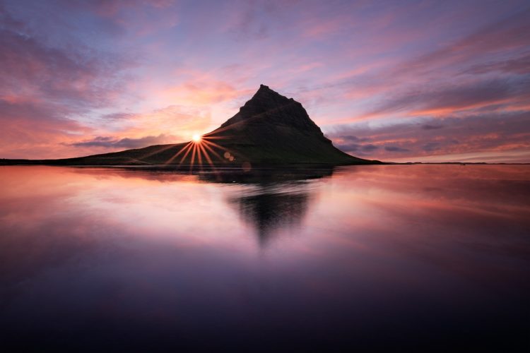Kirkjufell reflété dans la lagune au soleil de minuit, Grundarfjörður, Islande.