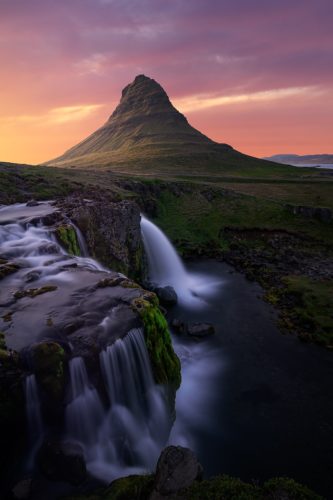 Cascade de Kirkjufellsfoss dévalant vers le Kirkjufell au soleil de minuit, Grundarfjörður, Islande.