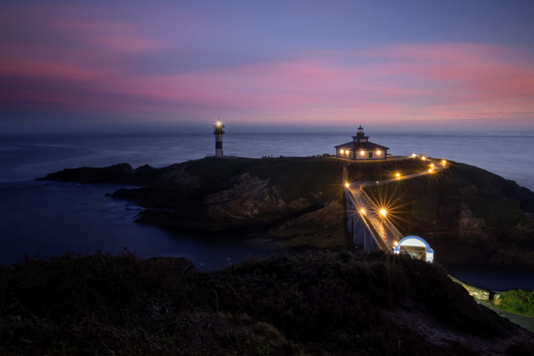 Phare d'Isla Pancha, Ribadeo, Galice, Espagne, à l'heure bleue du matin. Phare d'Isla Pancha illuminé à l'heure bleue, Ribadeo, Galice, Espagne.