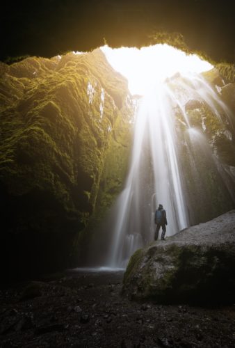 Silhouette face à la cascade Gljúfrabúi dans une grotte, Þórsmerkurvegur, Islande.