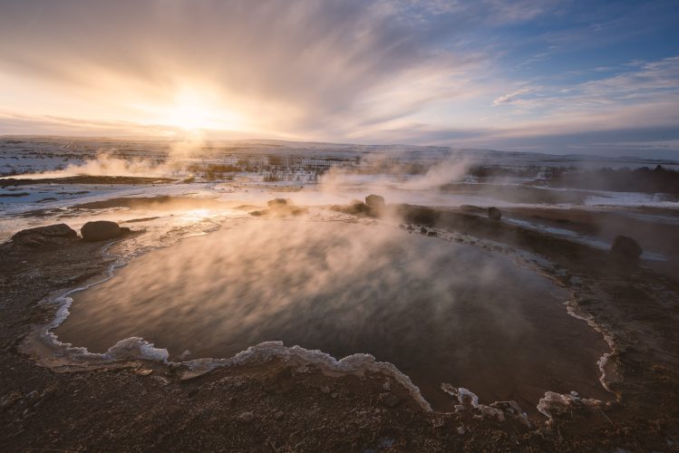 Source chaude de Konungshver fumante au lever du soleil, Geysir, Islande.