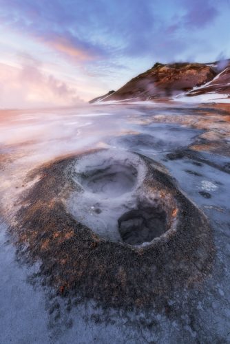 Fumerolle géothermique en forme de cratère au lever du soleil, Hverir, Islande.