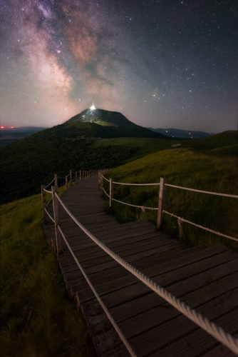 Chemin en bois du Puy Pariou menant vers le Puy de Dôme sous la Voie lactée, Puy-de-Dôme, Auvergne-Rhône-Alpes.