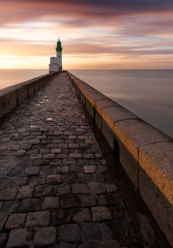 Phare du Tréport au bout d'une digue en pierre, coucher de soleil, Seine-Maritime, Normandie.