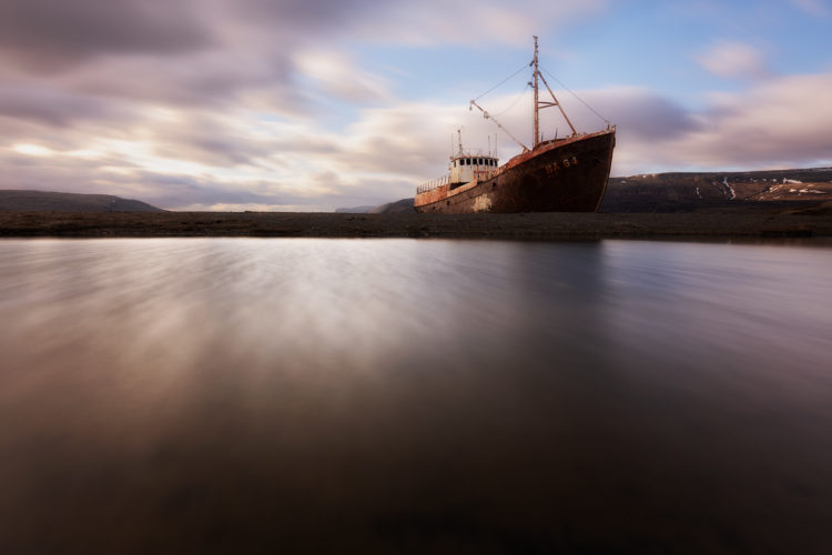 Épave rouillée du bateau Garðar échouée sur la côte, coucher de soleil, Westfjords, Islande.